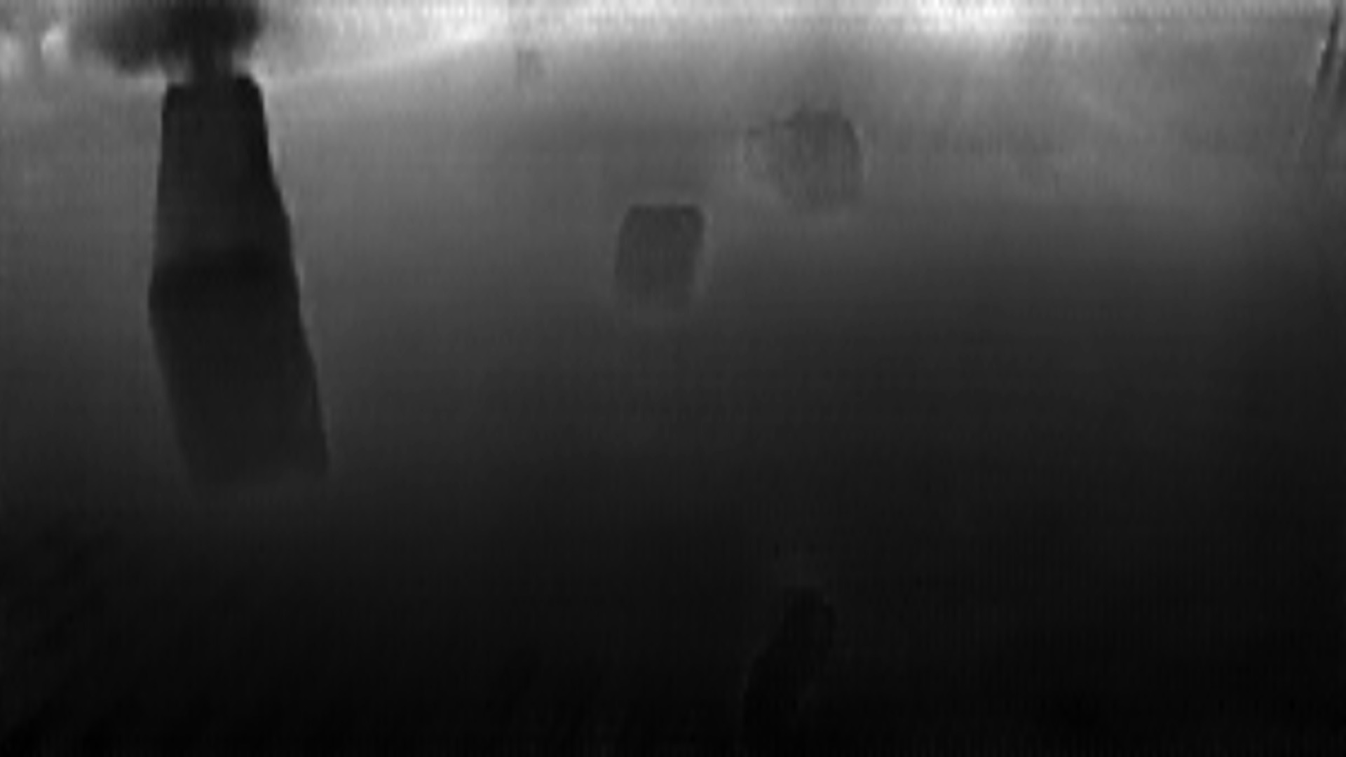 Black and White Depth estimation map of urban intersection with cars, bus, motorcycles navigating through a multi-lane crossing.